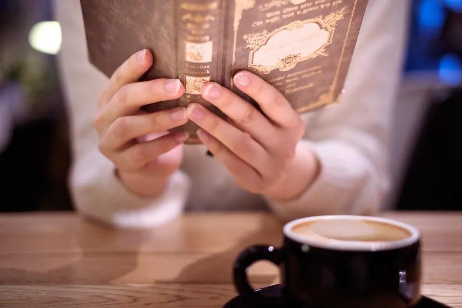 カフェで読書する女性の手元